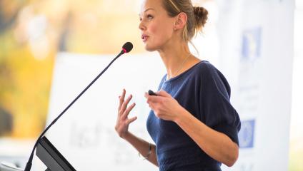 Female business leader speaking at a podium